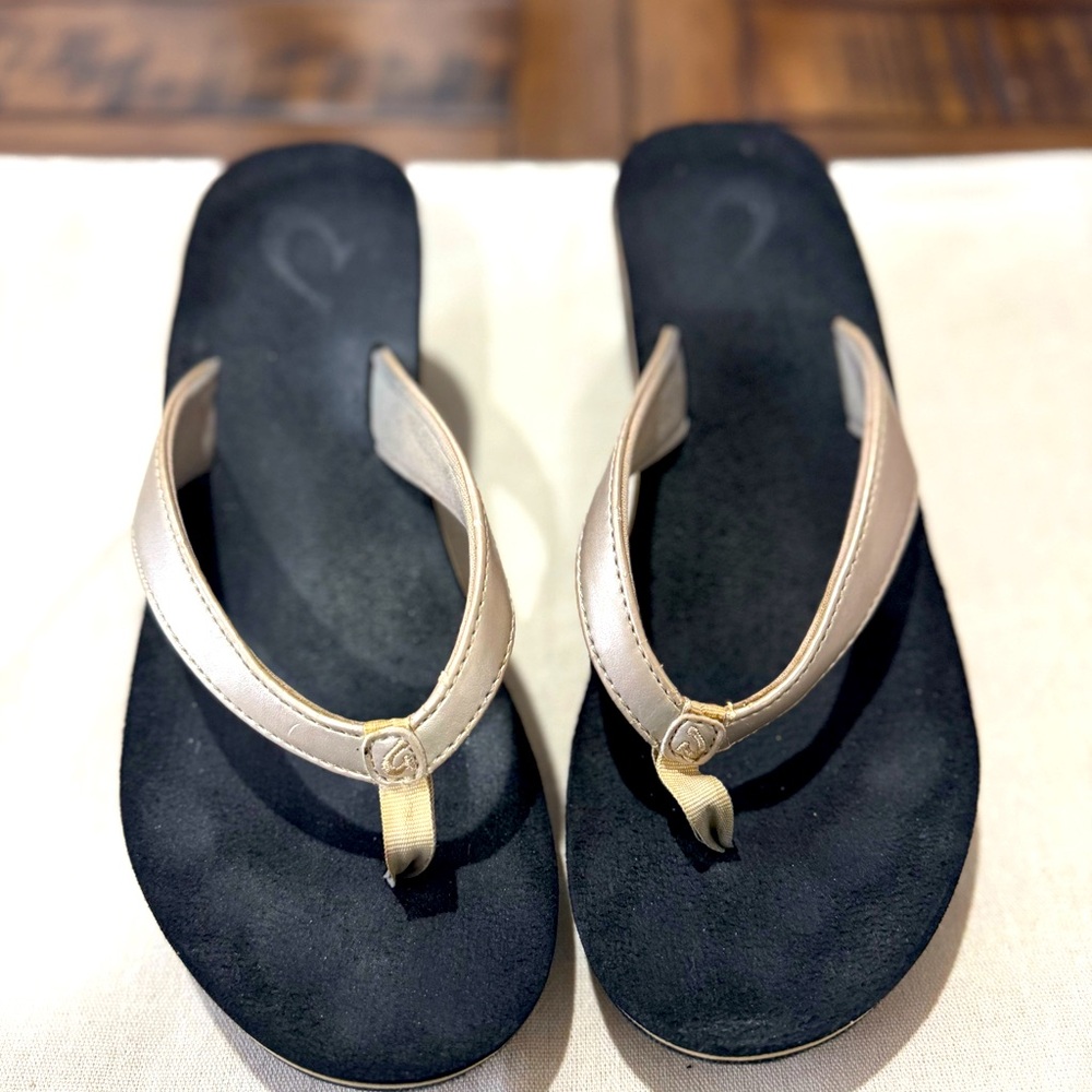 OluKai Pi'o Lua Wedge Thong Flip Flops. Gold/Black. Size 7
